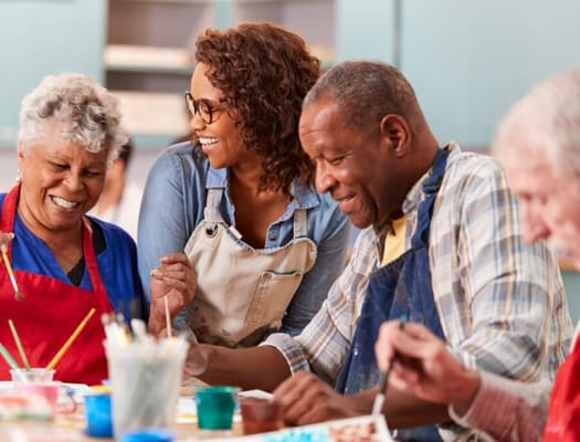 Residents participating in a painting activity at a table