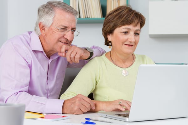 Couple using a laptop together in a bright room