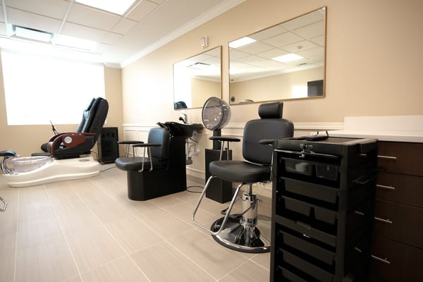 A hair salon area with empty chairs and mirrors