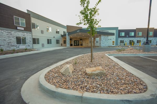 Front exterior of a senior living facility with landscaped entrance