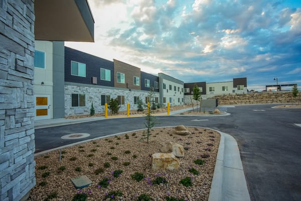 Exterior view of a senior living facility with landscaped area