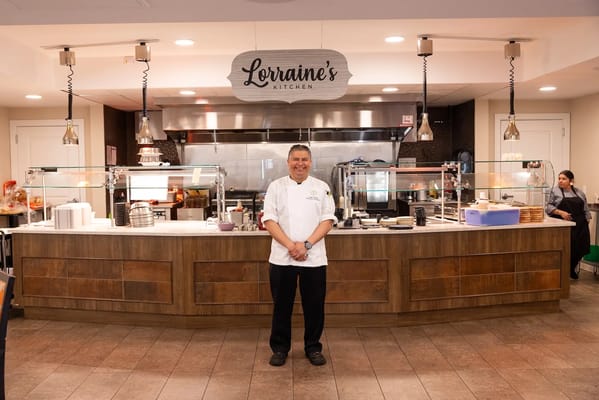 Chef standing in front of the dining area kitchen