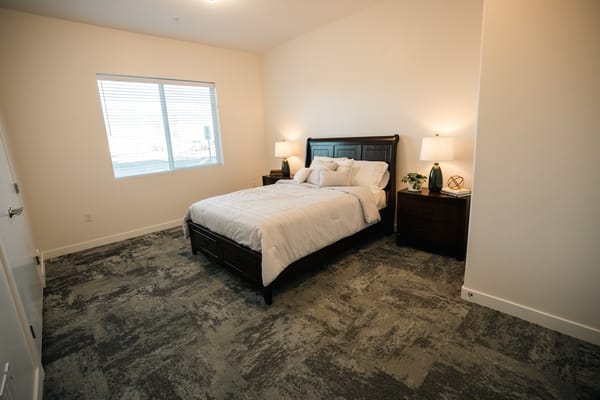 Bright interior of a private resident room with a bed
