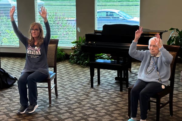Residents participating in a seated exercise class