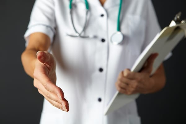Close-up of a healthcare professional reaching out to shake hands