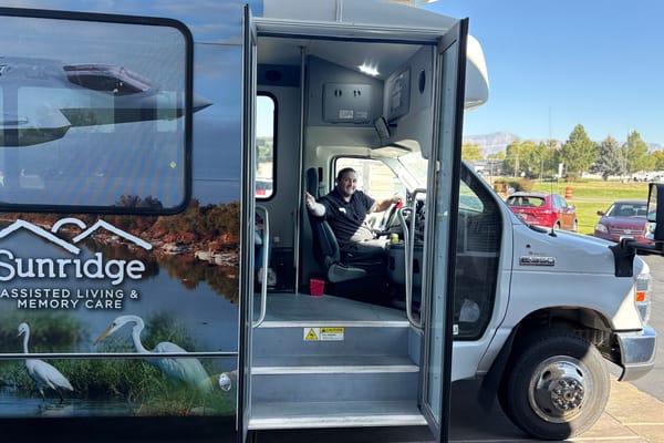Driver inside facility transport vehicle with scenic background