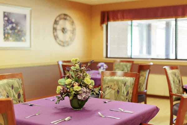 Dining area with flower centerpiece and purple tablecloths