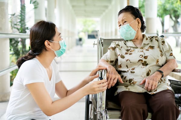 Caregiver assisting a resident in a hallway
