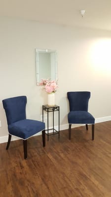 Pair of blue chairs beside a floral arrangement in a well-lit room