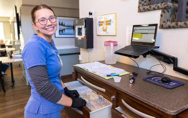 A staff member organizing resident files in an office