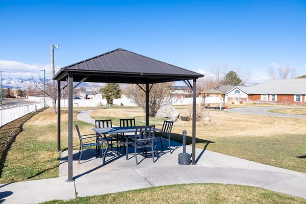 Outdoor gazebo with seating in a landscaped area