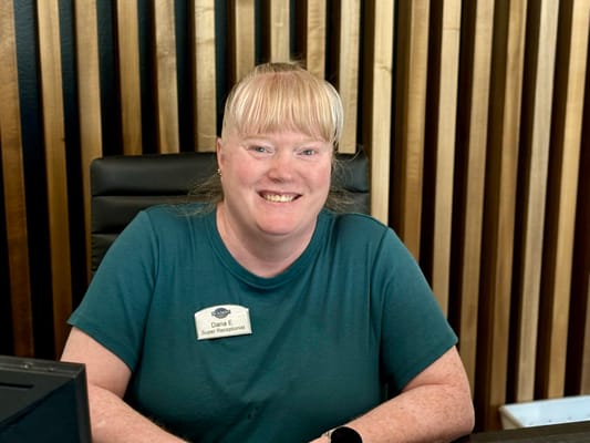 Reception staff member smiling at the front desk
