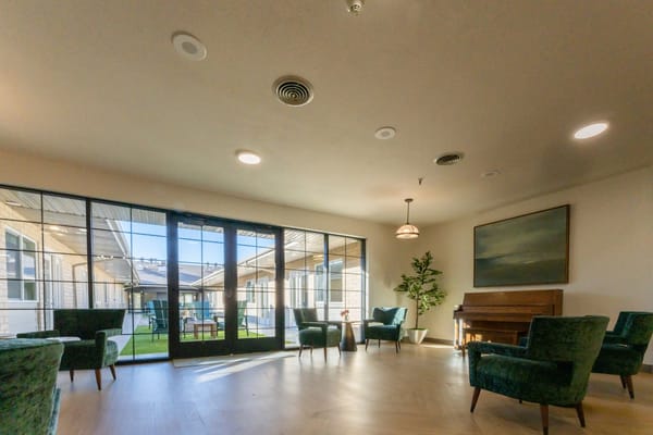 Bright interior common area with seating and piano