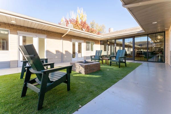 Outdoor seating area with fire pit and green lawn