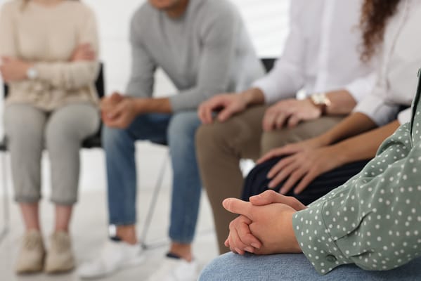 Group of people engaged in discussion during a therapy session