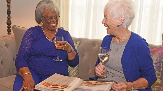 Two residents enjoying drinks and looking at a photo album