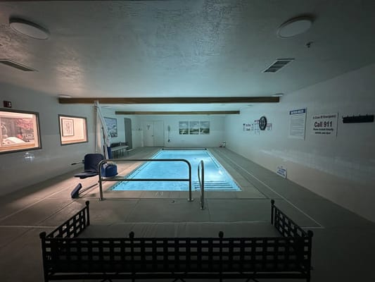 Indoor pool area with seating and emergency signage