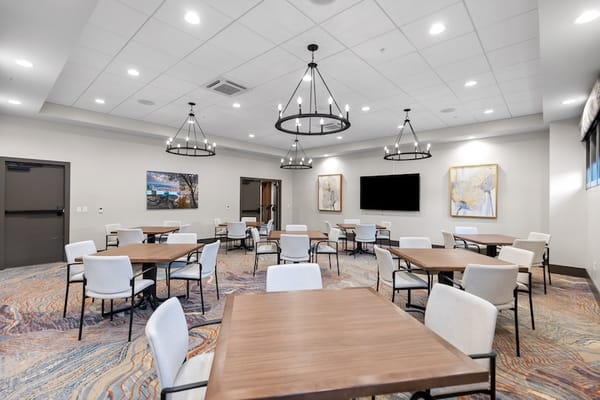 Common area with tables and chairs in a bright lobby