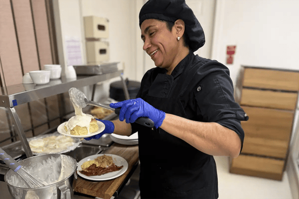 Staff member serving food in the kitchen