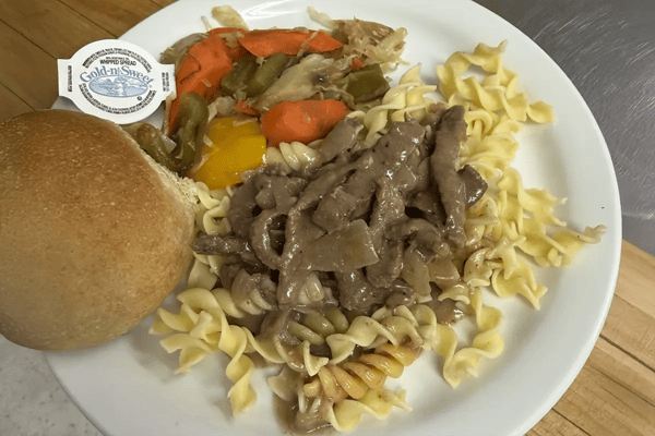 Plate of food with noodles, beef, and vegetables