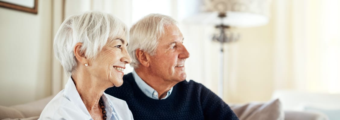 Two smiling seniors enjoying a moment together indoors