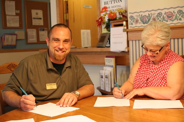 Staff and resident engaged in paperwork at a table