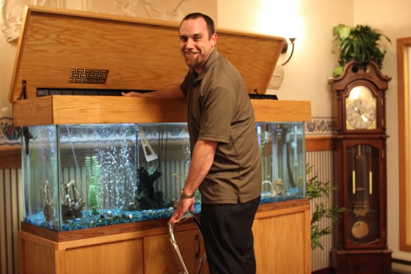 Staff member maintaining a large aquarium in the facility