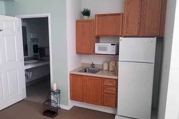 A kitchenette in a resident room with cabinetry and appliances