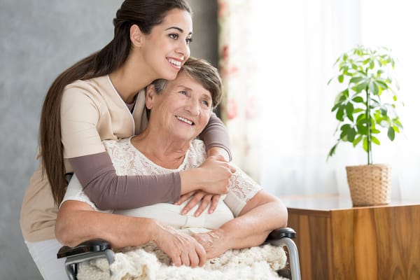 Caregiver embracing an elderly resident in a warm setting
