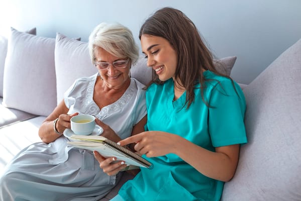 Caregiver and resident enjoying time together on a couch