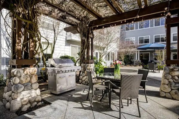 Outdoor dining area with grill under a pergola