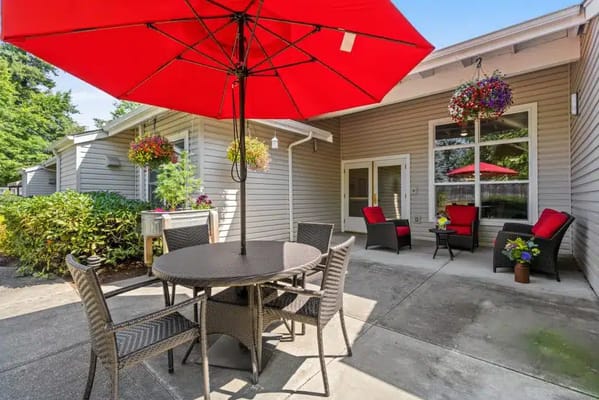 Outdoor seating area with red umbrella and comfortable chairs