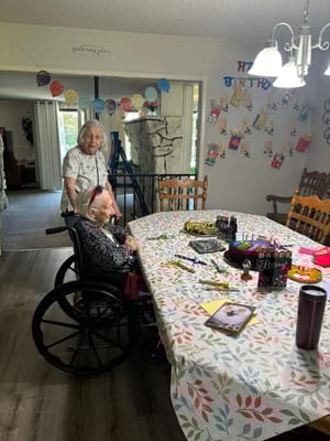 Residents celebrating a birthday in a decorated activity room