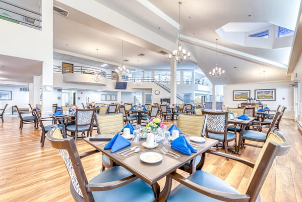 Bright dining room with neatly arranged tables and flowers