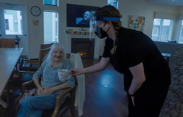 Staff member serving coffee to a resident in a common area