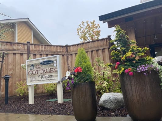 Exterior sign of The Cottages of Renton with flowers
