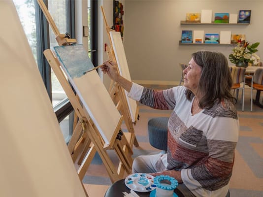 Resident painting in a common area of the facility