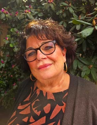 A smiling resident among green foliage