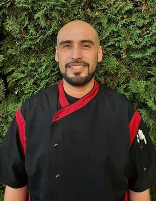 Chef in a kitchen uniform smiling