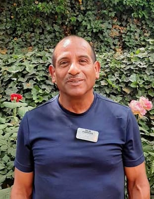 Staff member in a garden area with flowers