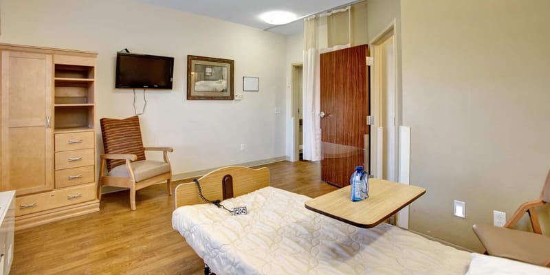 Interior view of a resident room with a bed and seating area