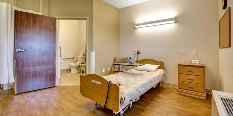Bright interior of a resident's bedroom with a hospital bed