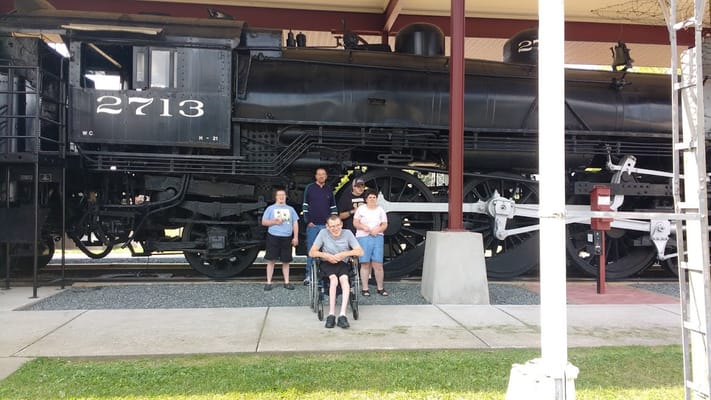 Residents posing in front of a vintage steam train