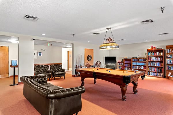 Common area with a pool table and bookshelves