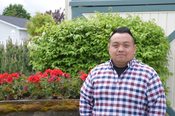 Person standing near flowers in an outdoor area