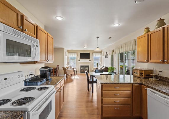 Bright, modern kitchen area with seating and a fireplace