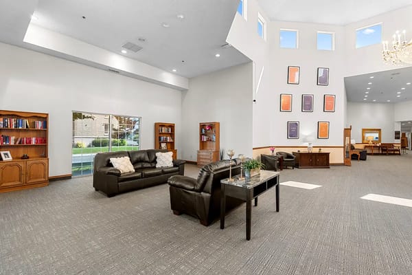 Common area with seating and bookshelves in a senior living facility