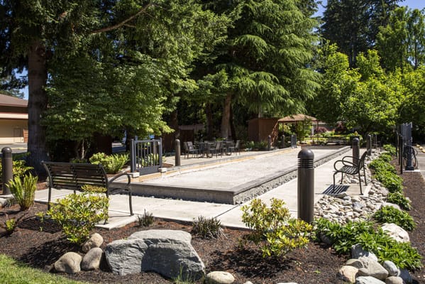 Outdoor bocce court with seating area and trees