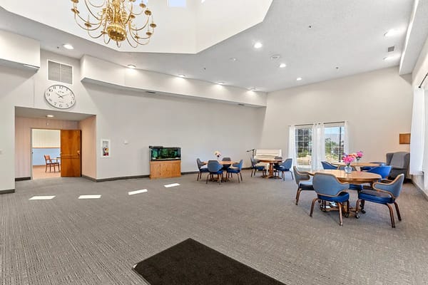 A bright common area with seating and piano