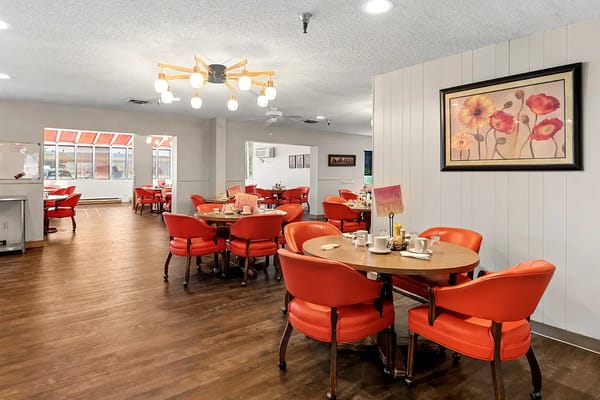 Bright dining area with red chairs and floral decor
